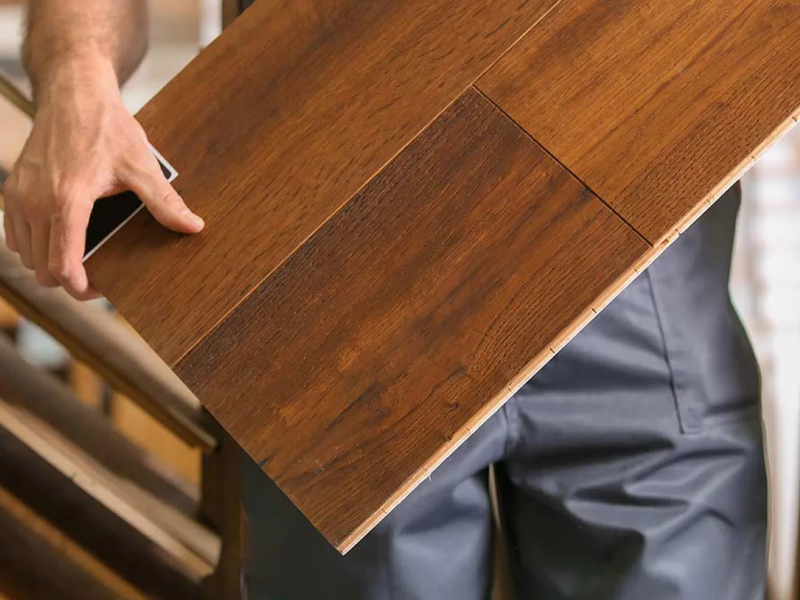 Flooring installer carrying a hardwood sample